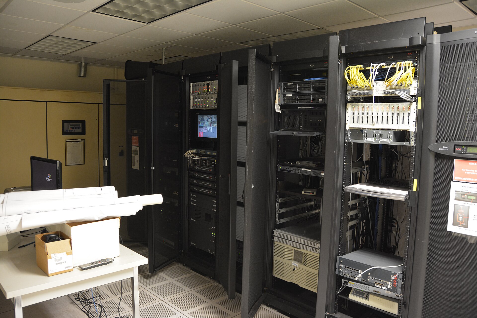 baie de serveurs dans une salle informatique, rangées de machines en fonctionnement