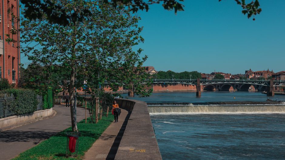 View of the river and bridge in Toulouse, Occitanie, France on a sunny day.