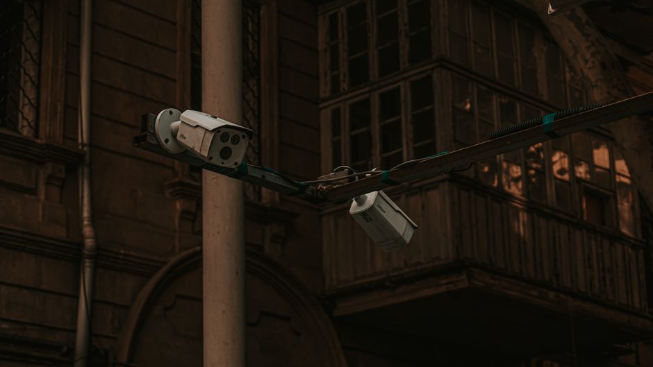 Street security cameras mounted on a pole in an urban environment, highlighting surveillance.