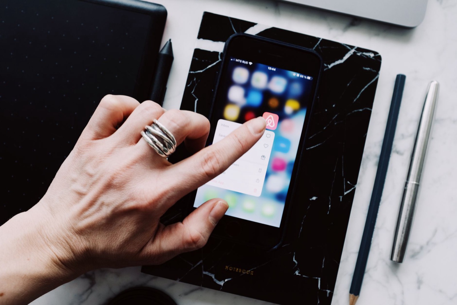 main qui touche l'icône de partage sur un écran de smartphone